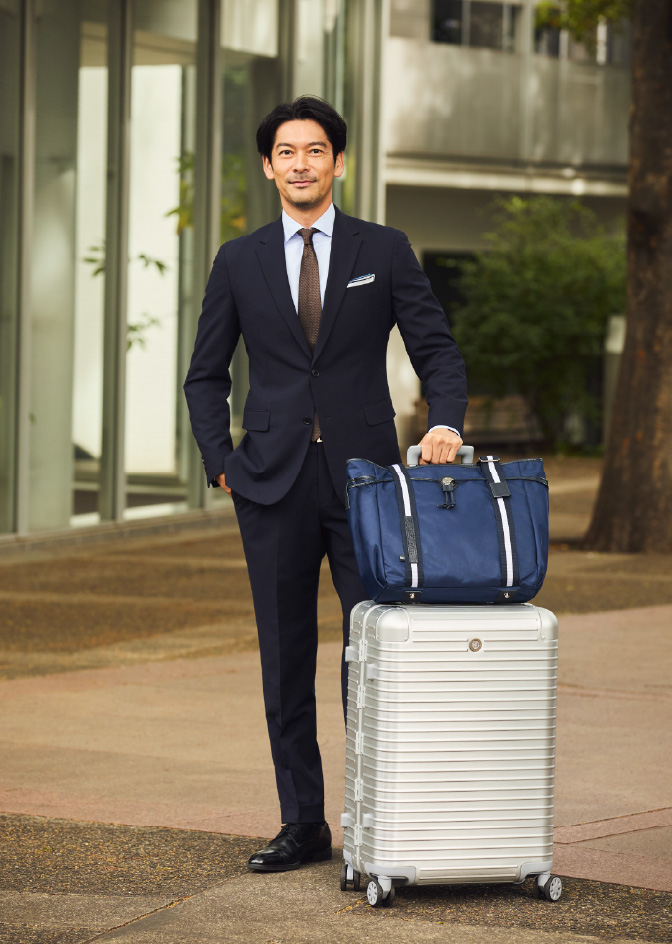 アリンナ 30th トートバッグ、モヴェンツァ スーツケースを手にするHIROYUKI KUBOTA